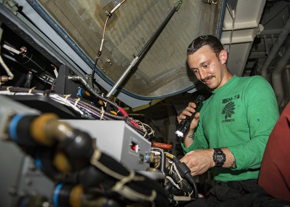 USS Normandy Sailor Conducts Daily Check On MH-60R Sea Hawk Helicopter