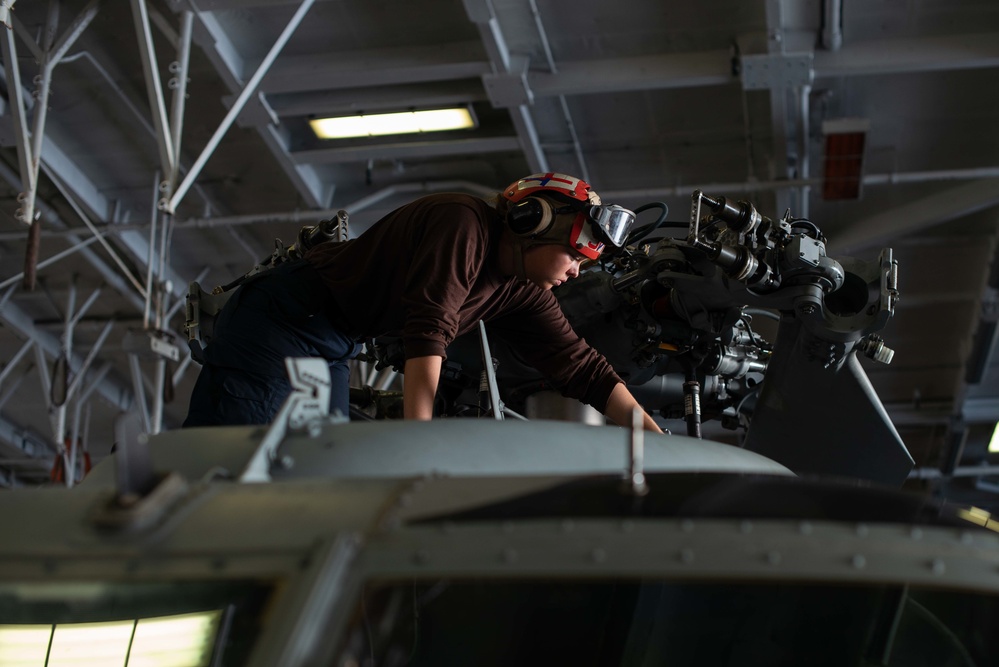 U.S. Sailor conducts helicopter maintenance