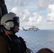 U.S Navy Naval Aircrewman flies adjacent to an MH-60S Sea Hawk over the Atlantic Ocean