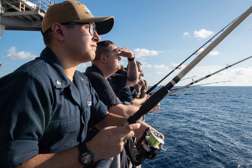 U.S. Sailors fish off the fantail