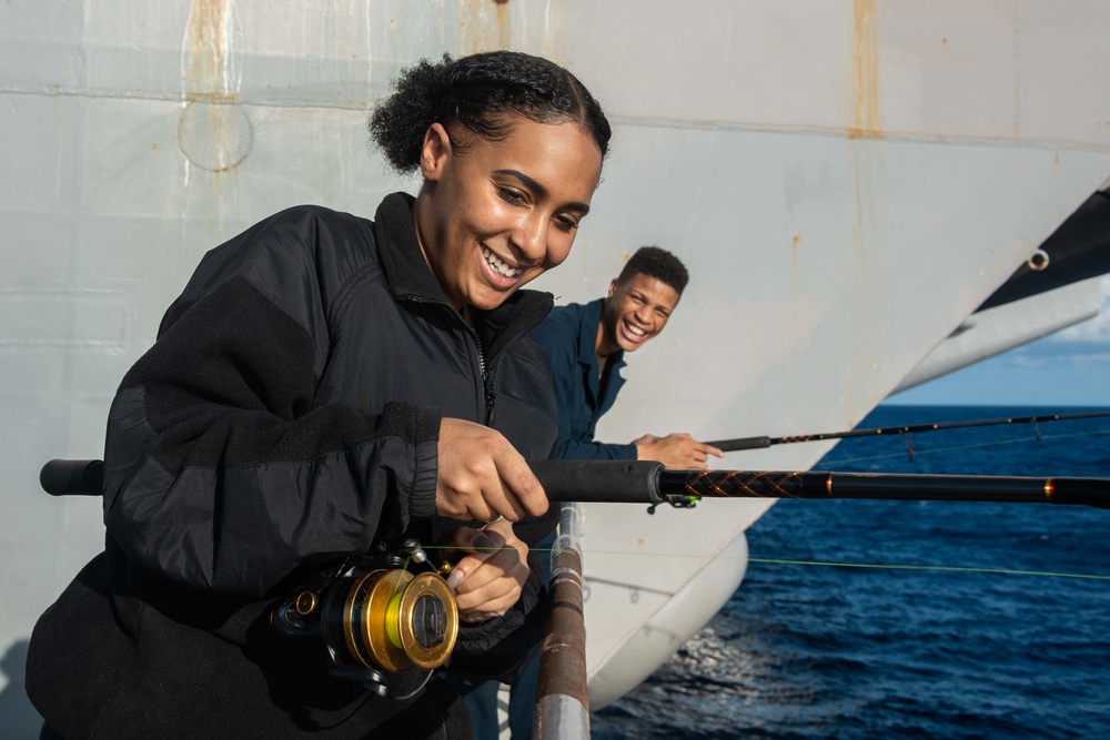 U.S. Sailors fish off the fantail