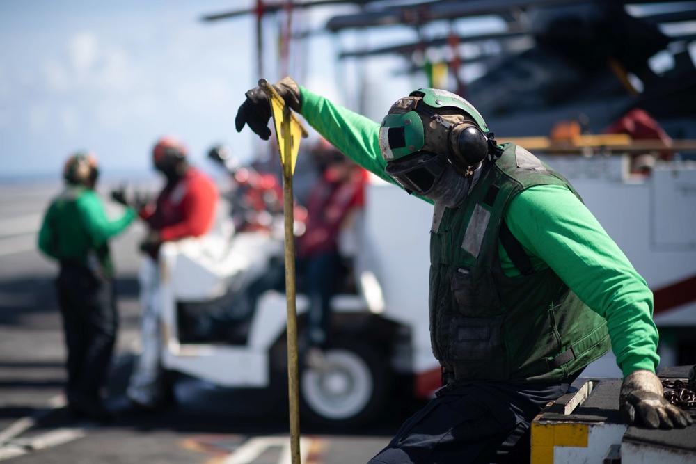 U.S. Navy Aviation Boatswain's Mate (Handling) Airman Apprentice Chris Blaisdell, from Lancaster, California, awaits An F/A-18F Super Hornet