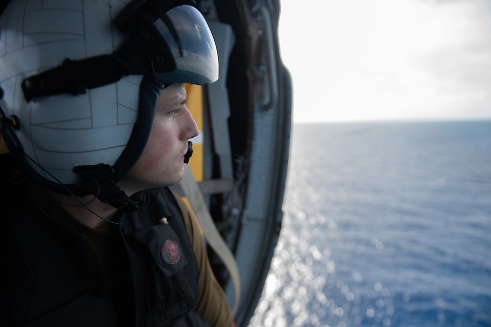 U.S Navy Naval Aircrew Man monitors flight activity from the cabin of an MH-60S Sea Hawk in the Atlantic Ocean