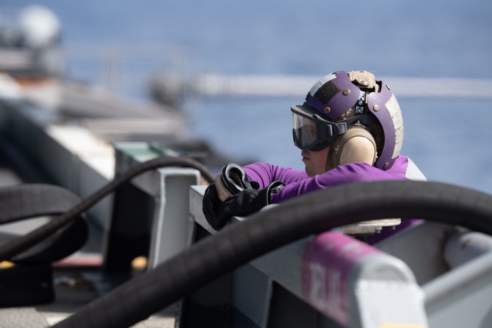 U.S. Navy Aviation Boatswain's Mate (Fuel) 2nd Class Joshua Plummer, from Jefferson, Maine, mans a fuel line