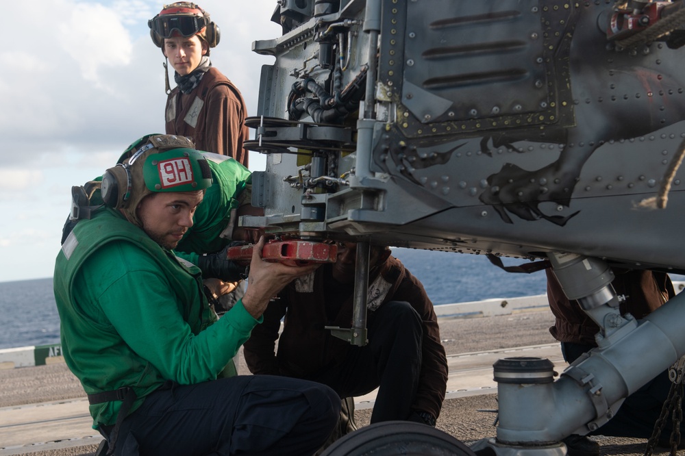 A Sailor preflight checks an MH-60S