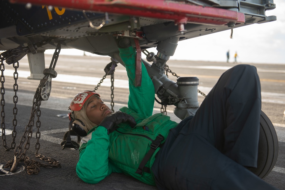 A Sailor preflight checks an MH-60S