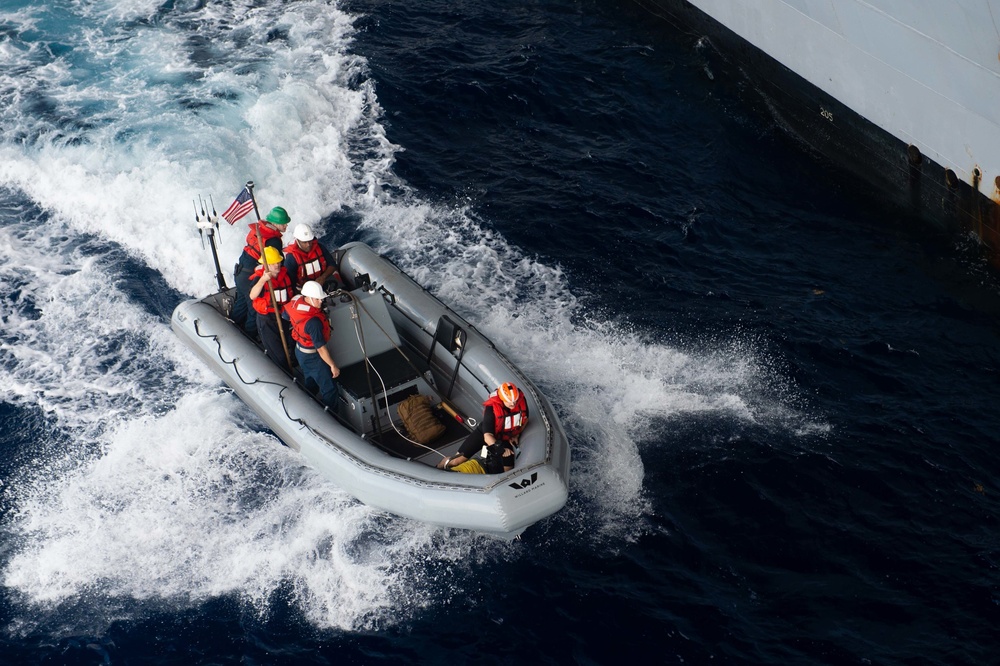 Sailors operate a rigid-hull inflatable boat