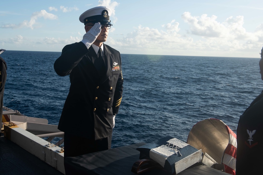U.S. Navy Religious Programs Specialist Chief Timothy Cambiado renders honors during a burial at sea