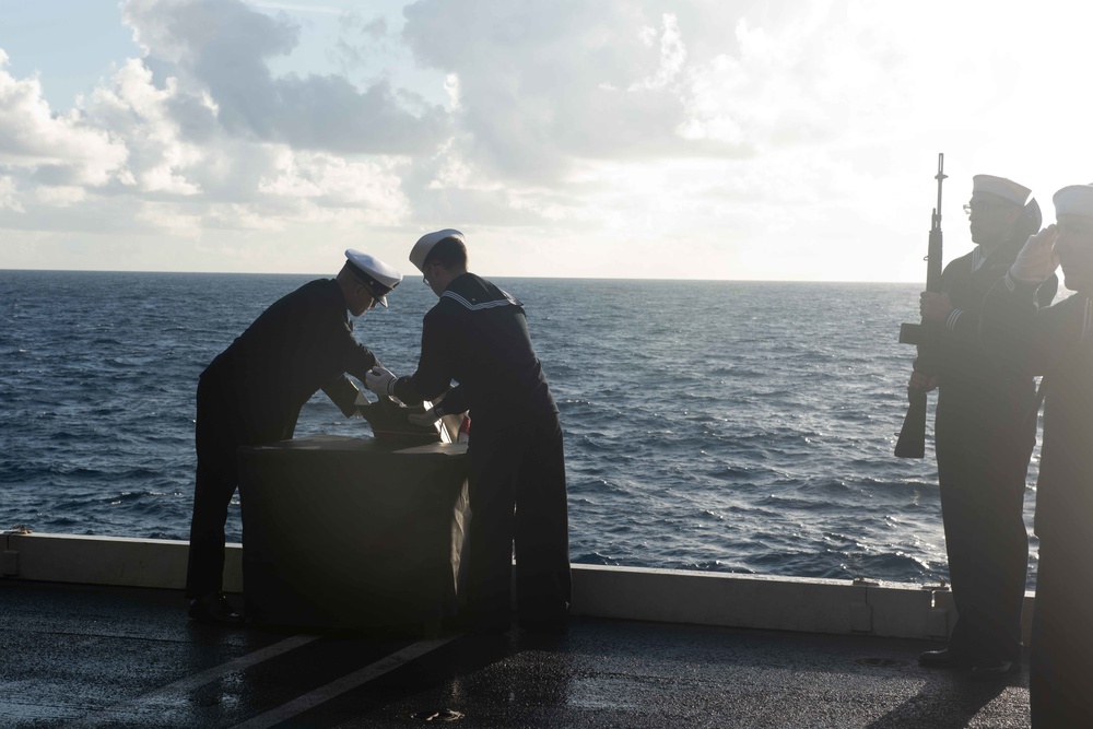 U.S. Sailors participate in a burial at sea on an aircraft elevator aboard the aircraft carrier USS John C. Stennis (CVN 74)