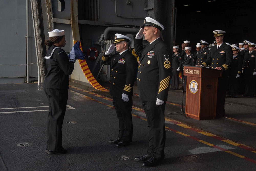 U.S. Navy Religious Programs Specialist 2nd Class Che’Lese Bowman, left, delivers the American flag to Capt. Randy Peck, commanding officer of the aircraft carrier USS John C. Stennis (CVN 74)