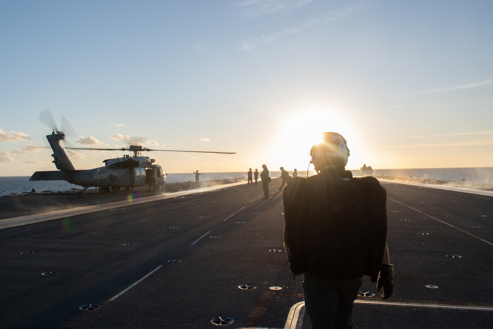 U.S. Navy Naval Aircrewman prepares to board an MH-60S Sea Hawk from the flight deck of the aircraft carrier USS John C. Stennis