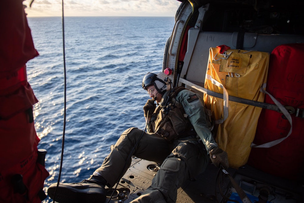 U.S. Navy Naval Air Crewman conducts a vertical replenishment-at-sea exercise with the aircraft carrier USS John C. Stennis