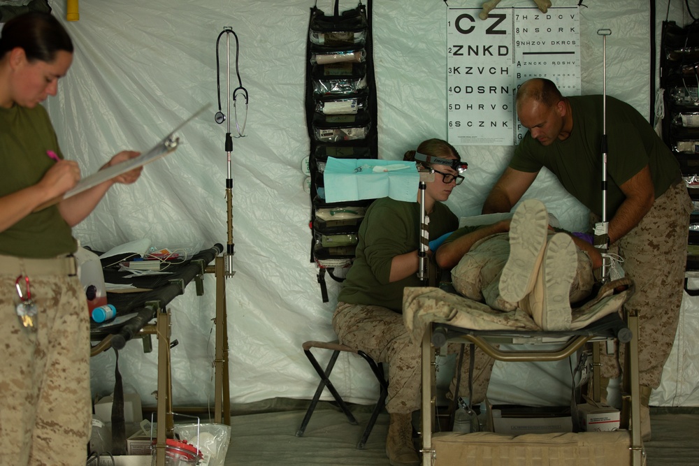 Corpsman performs suture on Marine