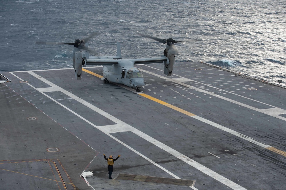 U.S. Navy Sailor guides an Osprey to land