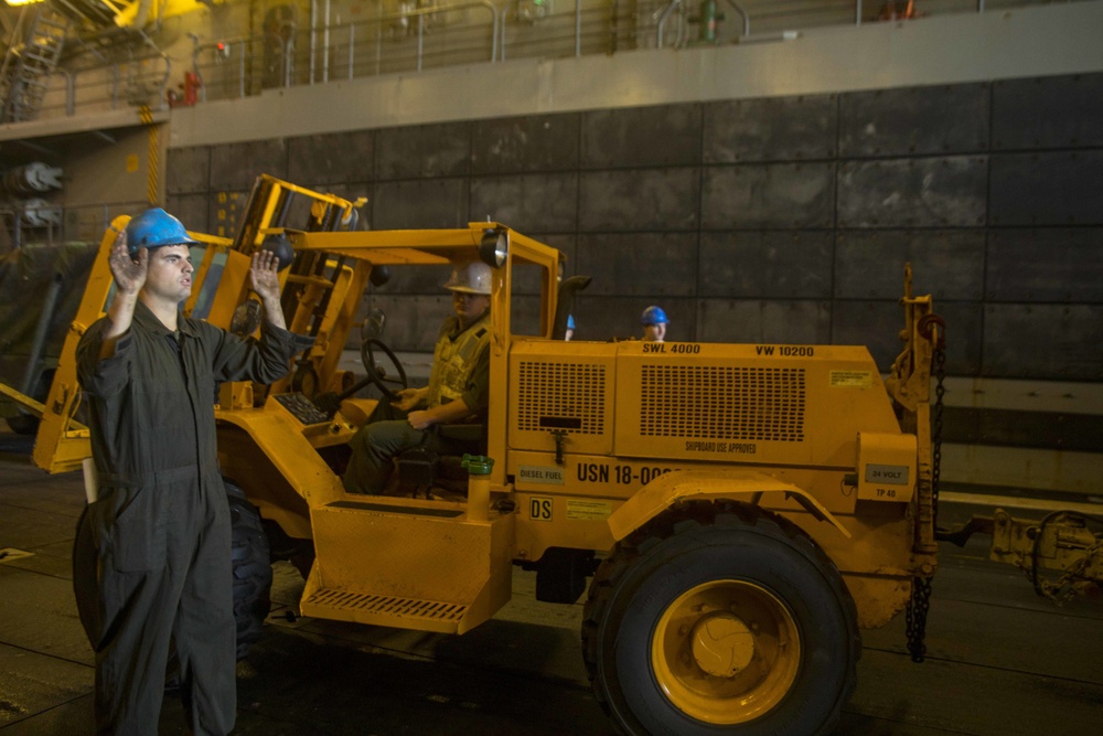 Marines reverses a forklift