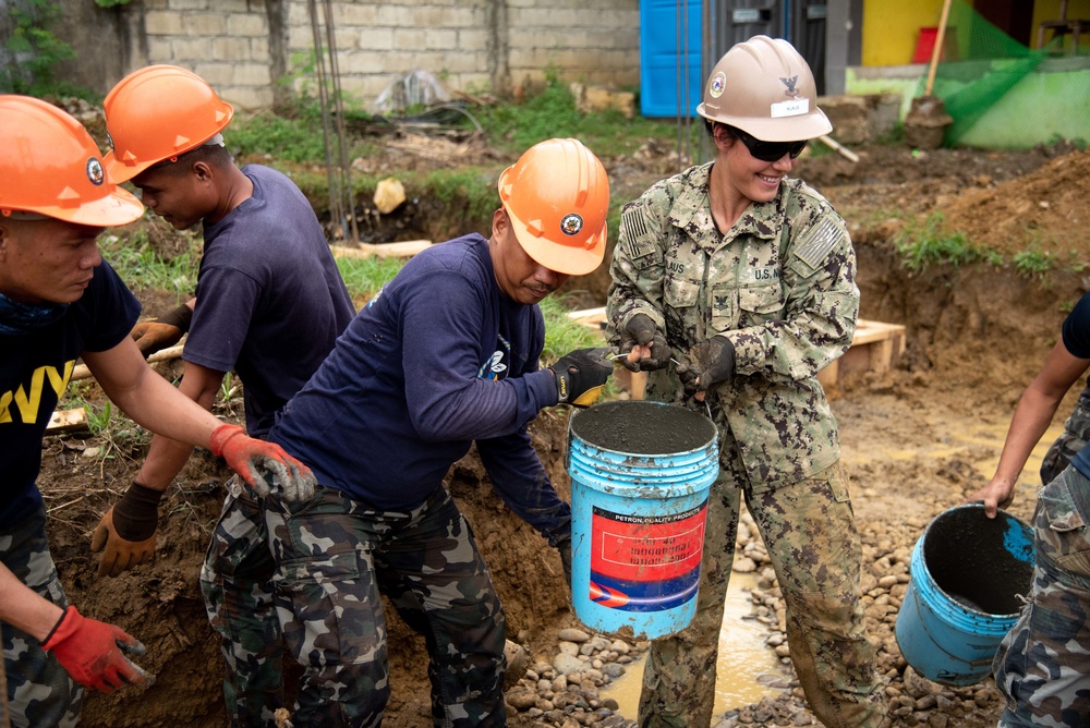 NMCB-5’s Detail Palawan and the Armed Forces of the Philippines 2nd NMCB work together to place concrete at Malatgao Elementary School