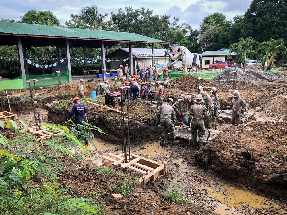 NMCB-5’s Detail Palawan and the Armed Forces of the Philippines 2nd NMCB work together to place concrete at Malatgao Elementary School