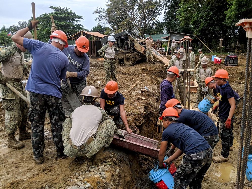 NMCB-5’s Detail Palawan and the Armed Forces of the Philippines 2nd NMCB work together to place concrete at Malatgao Elementary School