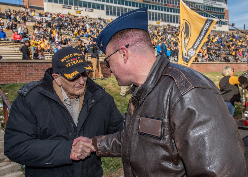 509th Bomb Wing commander shakes hands with a World War II veteran during the University of Missouri military appreciation game