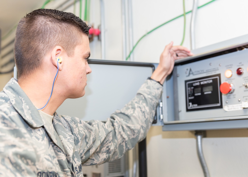 Electrical power production Airman checks the amps and voltage on a load meter