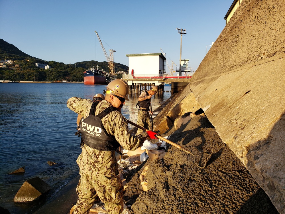 U.S. Navy Seabees deployed with Naval Mobile Construction Battalion 5’s Detail Sasebo place concrete for the seawall port repairs on Commander Fleet Activities Sasebo