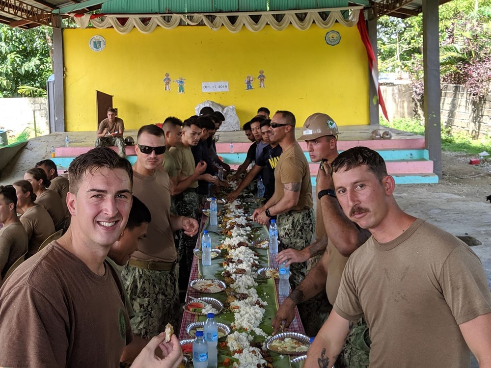 U.S. Navy Seabees deployed with NMCB-5’s Detail Palawan and Seabees from the Armed Forces of the Philippines 2nd NMCB eat a traditional Palawan meal together