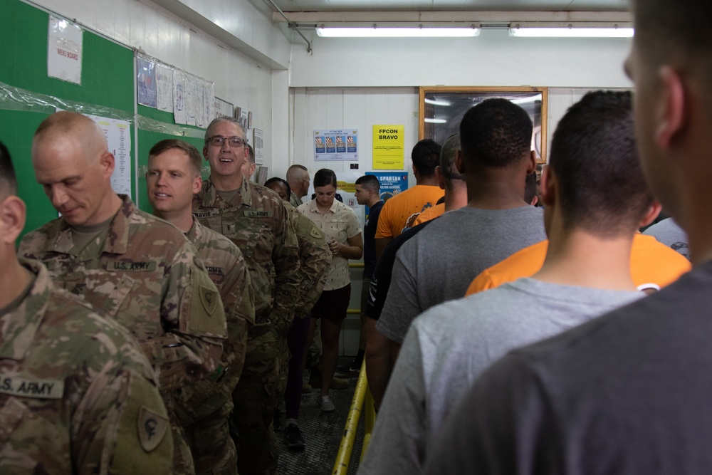 Service members stand in line for a Thanksgiving meal