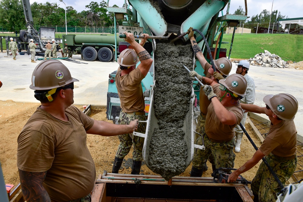 U.S. Navy Seabees with NMCB-5 place concrete at Camp Shields