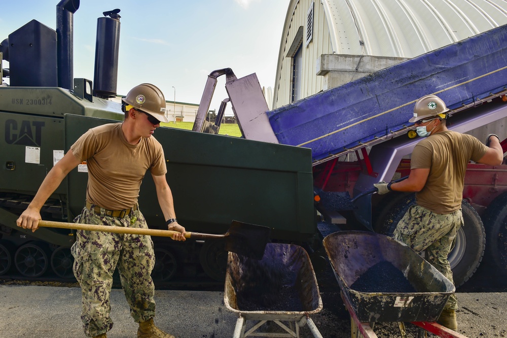 U.S. Navy Seabees with NMCB-5 place asphalt at Camp Shields