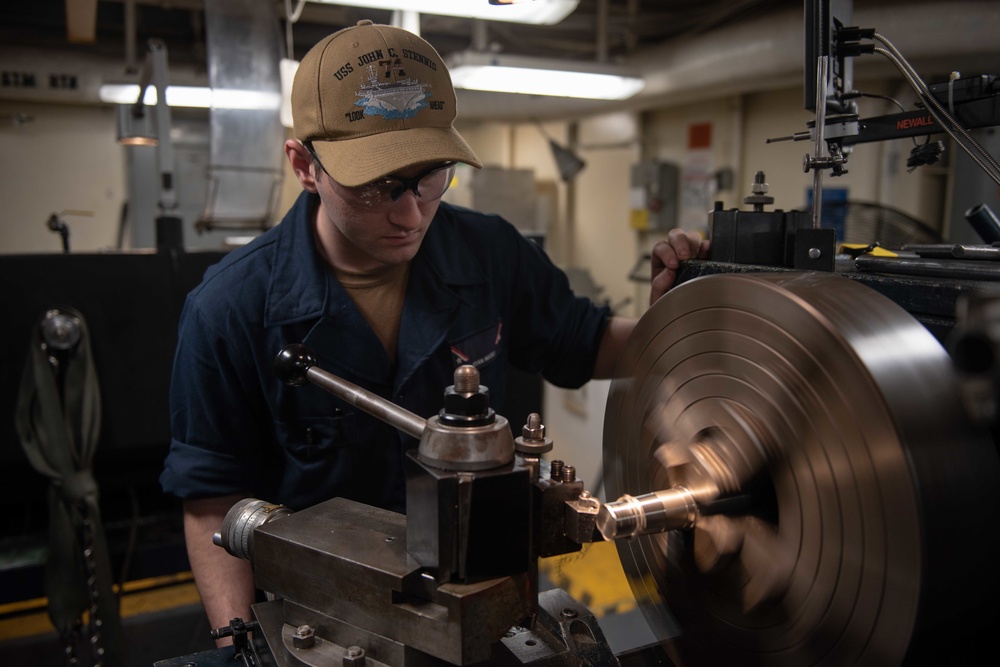 A Sailor calibrathes a lathe