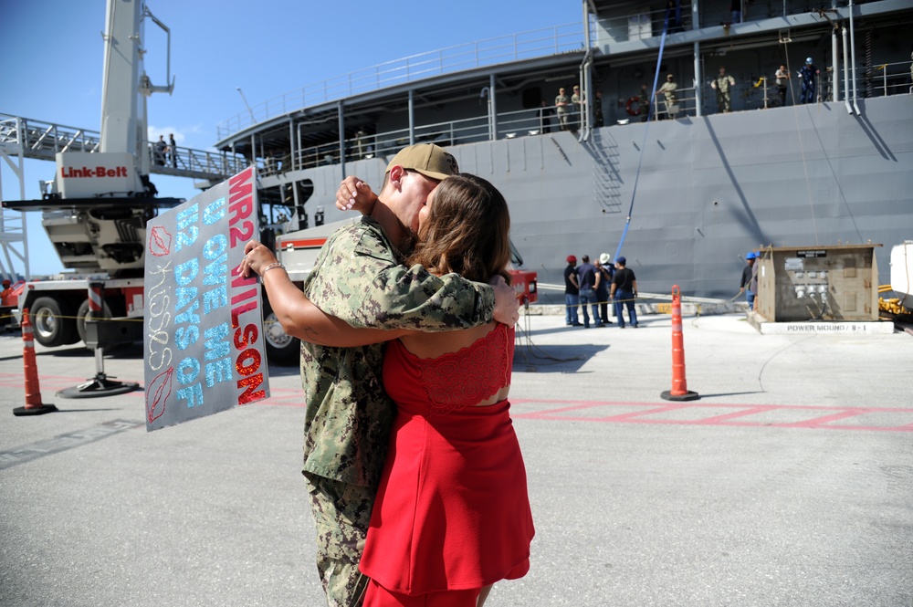 Machinery Repairman 2nd Class Tyler Wilson, from Syracuse, New York, assigned to the submarine tender USS Emory S. Land (AS 39), kisses his wife during a homecoming gathering