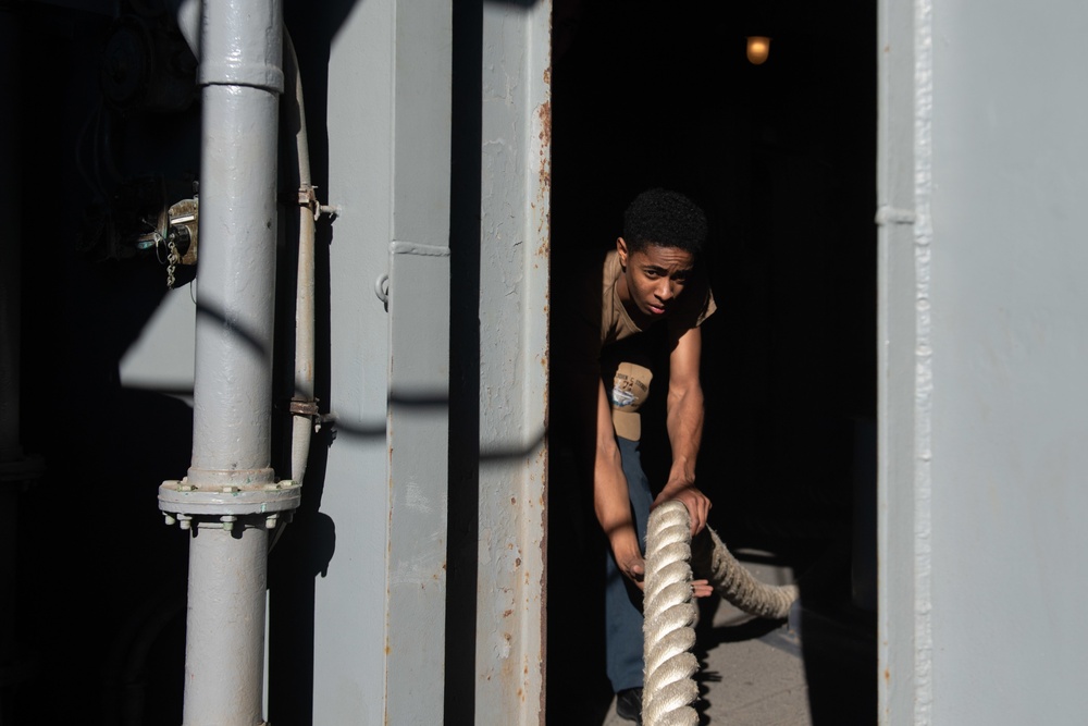 U.S. Sailor pulls in mooring lines