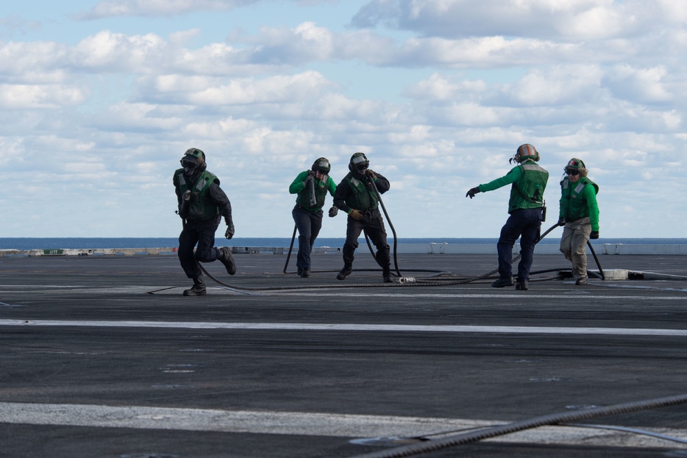 U.S. Sailors change an arresting gear wire