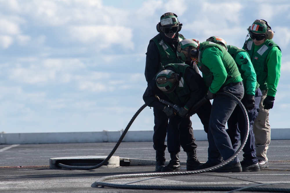 U.S. Sailors change an arresting gear wire