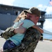 Chief Hull Maintenance Technician Leonard Roach, assigned to the submarine tender USS Emory S. Land (AS 39), hugs his daughter during a homecoming gathering at Polaris Point