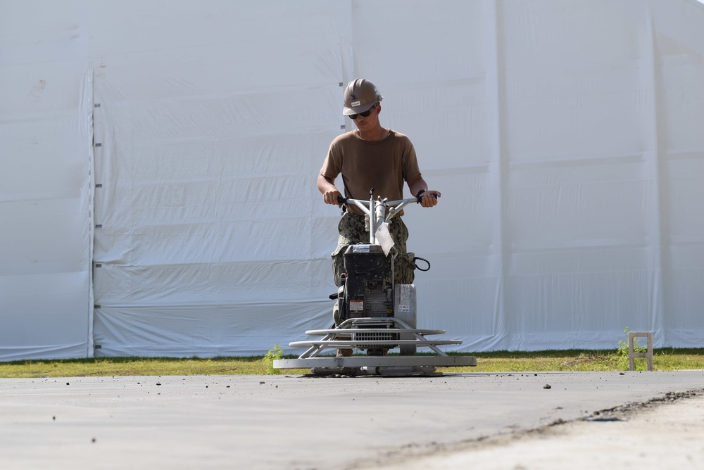 U.S. Navy Seabees from NMCB 5’s Detail Diego Garcia place concrete in support of the U.S. Air Force