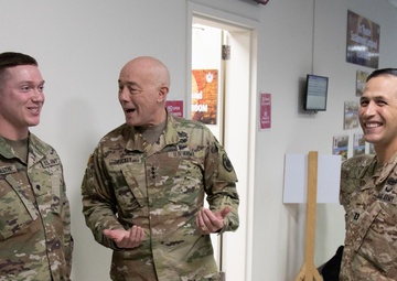 Lt. Gen. Charles D. Luckey presents Spc. Dakota Vanidestine with a challenge coin