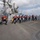 USS Wayne E. Meyer (DDG 108) Replenishment-at-Sea A line of naval personnel aboard a warship are engaged in a line-handling or replenishment-at-sea evolution, pulling a rope or line in unison across the ship's deck. All crew members are wearing blue hard hats and red inflatable life vests, indicating a safety-conscious underway operation. The vessel appears to be a U.S. Navy guided-missile destroyer based on visible superstructure and equipment.