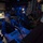 USS Wayne E. Meyer (DDG 108) Combat Information Center Watch Two U.S. Navy personnel are seated at workstations in what appears to be a Combat Information Center (CIC) or similar tactical operations room aboard a naval vessel. Both individuals are wearing headsets and blue Navy coveralls, operating computer consoles with illuminated keyboards and tactical display screens. The room is dimly lit with blue ambient lighting, characteristic of a shipboard operations center.