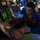 USS Wayne E. Meyer (DDG 108) Combat Information Center Watch Standing A U.S. Navy sailor is working at a combat information center (CIC) or operations room aboard a naval vessel. The sailor, wearing a blue uniform with 'U.S. NAVY' visible and a communications headset, is writing on a transparent plotting board while monitoring multiple electronic displays. The dimly lit environment with green and red indicator lights is characteristic of a shipboard tactical operations center.