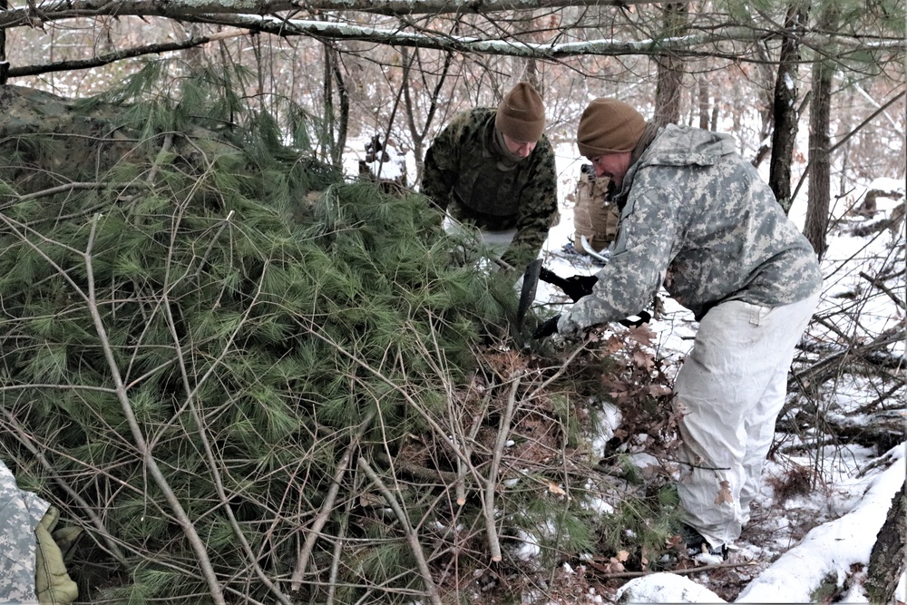 Cold-Weather Operations Course students build improvised shelters, survive outdoors