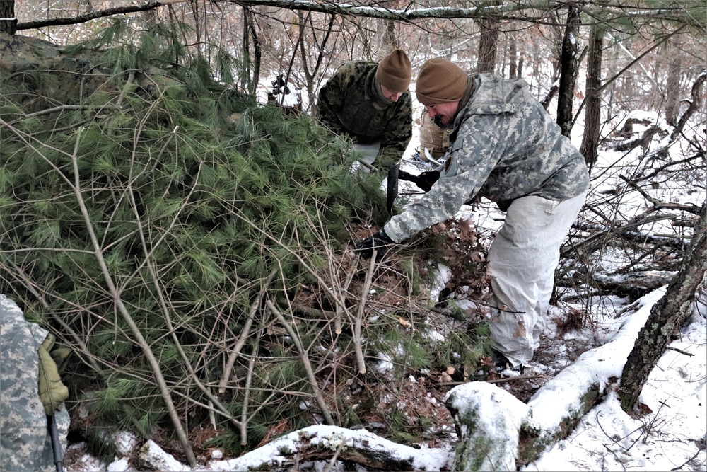 Cold-Weather Operations Course students build improvised shelters, survive outdoors