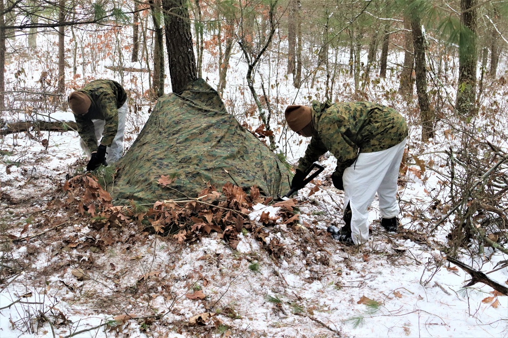 Cold-Weather Operations Course students build improvised shelters, survive outdoors