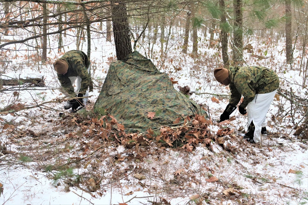 Cold-Weather Operations Course students build improvised shelters, survive outdoors