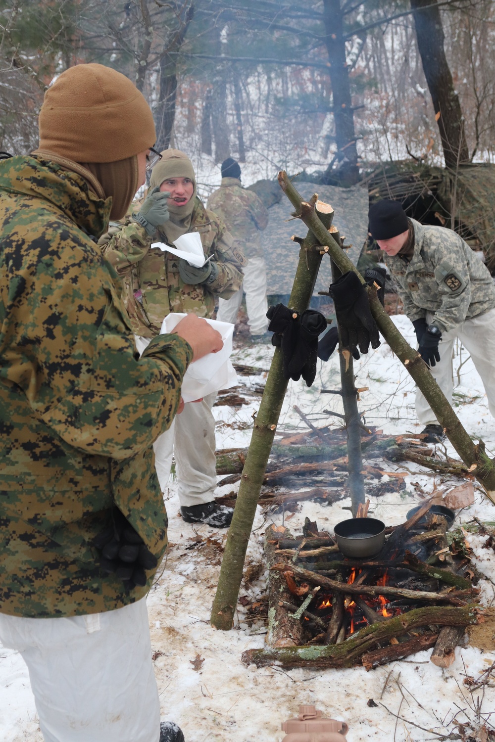 Cold-Weather Operations Course students build improvised shelters, survive outdoors