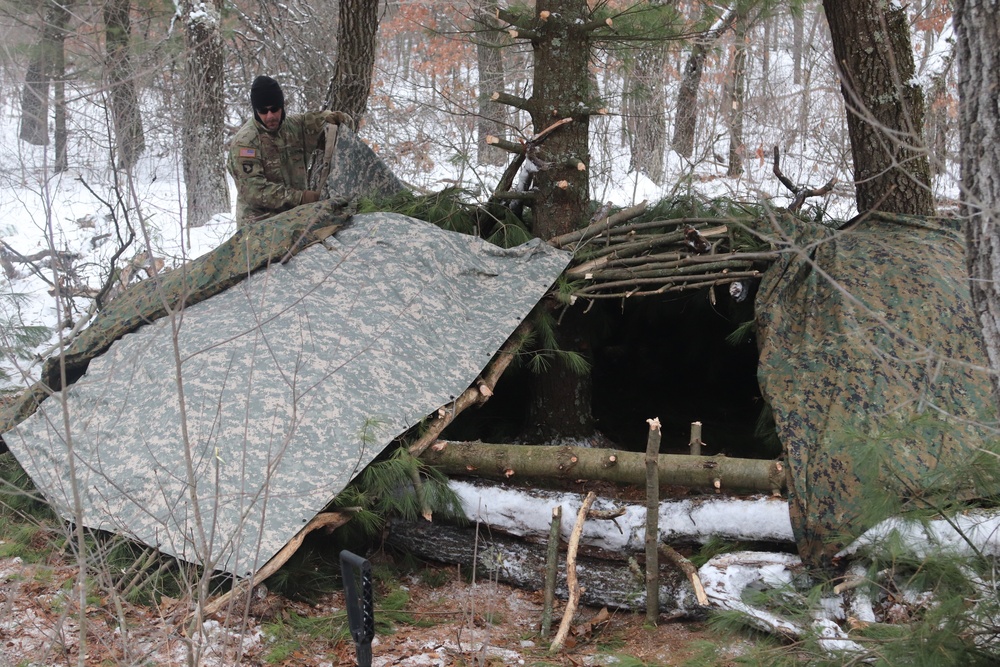 Cold-Weather Operations Course students build improvised shelters, survive outdoors