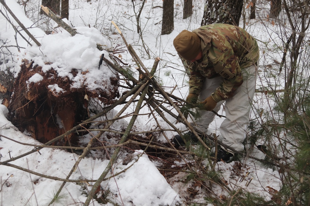 Cold-Weather Operations Course students build improvised shelters, survive outdoors