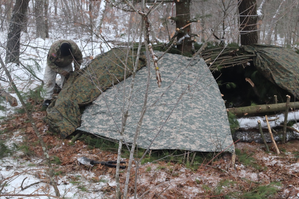 Cold-Weather Operations Course students build improvised shelters, survive outdoors