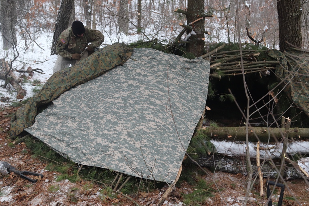 Cold-Weather Operations Course students build improvised shelters, survive outdoors