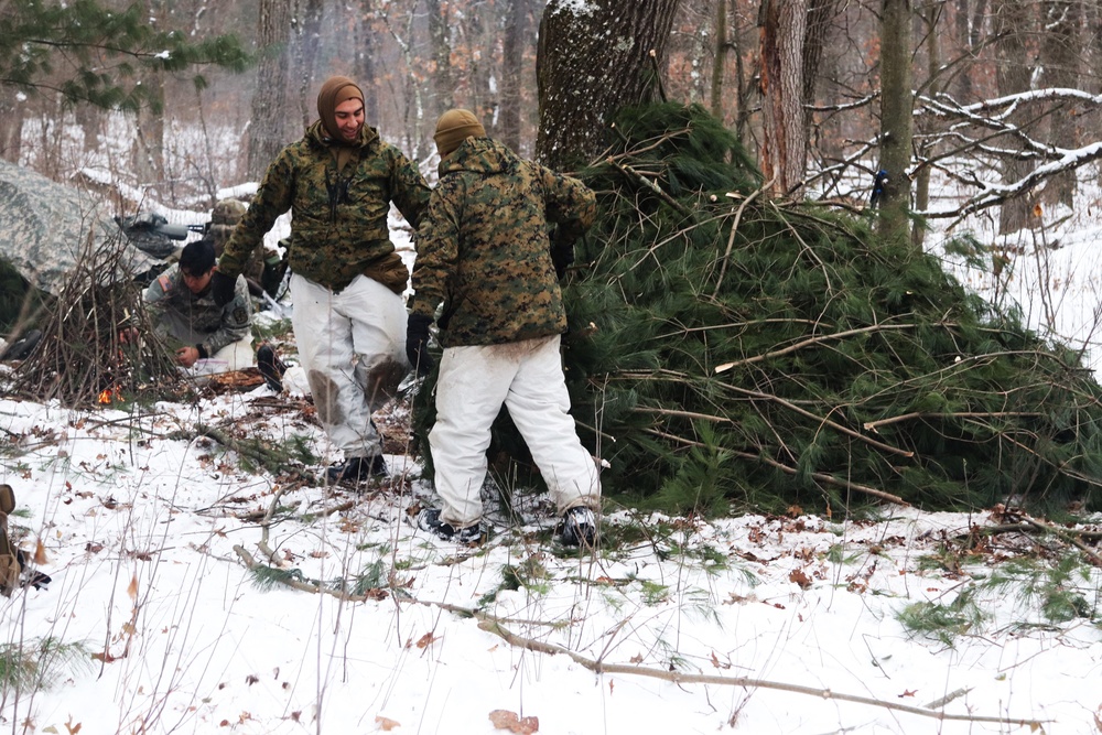 Cold-Weather Operations Course students build improvised shelters, survive outdoors